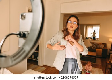 Freelance Interior Designer Holding A Fabric Swatch While Recording A Video. Influencer Advertising Her Creative Work On Her Social Media Channel. Blogger Mom Creating Content For Her Followers.