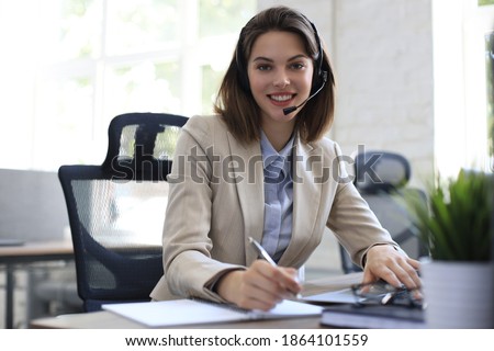 Freelance operator talking with headsets and consulting clients from office.