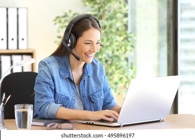 Freelance operator working in telemarketing on line with headsets and a laptop in a desktop at office