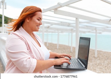 Freelance. Portrait Of Caucasian Smiling Woman Working At A Laptop. Plus Size Model. Side View. Outdoor. Concept Of Remote Work And Online Business