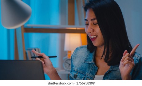 Freelance Smart Business Women Listening Music After Use Laptop Work Hard In Workplace In Living Room At Home At Night. Happy Young Asian Girl Sitting On Desk Work Overtime, Dance Enjoy Relax Time.