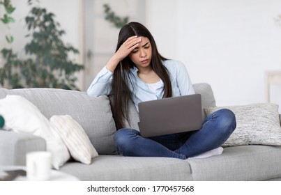 Freelance Stress. Concerned Asian Girl Freelancer Tired After Work On Laptop At Home, Having Problems With Project, Sitting On Couch, Free Space