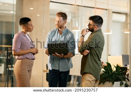Freelance worker using laptop while communicating with his colleagues during the meeting at corporate office.
