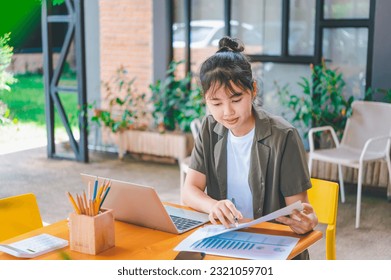 Freelance worker working on documents with graphs. and information about finances on laptops in cafes