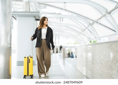 Freelance young adult asian woman walking with travel luggage for business trip. Smile face long hair at station platform on day. Urban people lifestyles. - Powered by Shutterstock