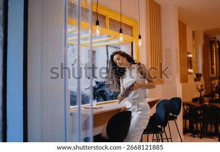 Freelancer interacts with tablet while standing, symbolizing mobility, digital transition and seamless multitasking in a modern hybrid workspace culture.