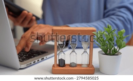 A freelancer juggles multiple devices while racing against hourglasses, symbolizing time management, productivity, stress, adaptability, and the challenge of meeting deadlines in a fast-paced world.
