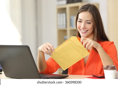 Freelancer opening a padded envelope in an office or home