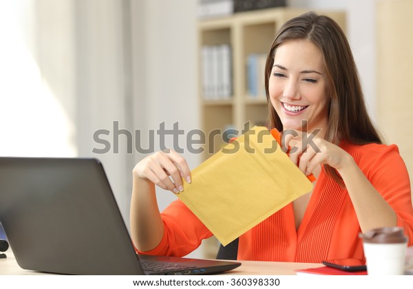 Freelancer\
opening a padded envelope in an office or\
home