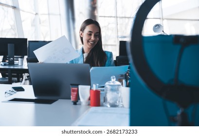 Freelancer smiling while reviewing documents at laptop, symbolizing digital confidence, balanced workflow and effective integration of online and offline tools. - Powered by Shutterstock - Get 15% off with code: PIKWIZARD15