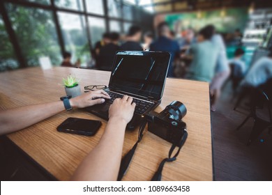 Freelancer using computer laptop at coffee shop.