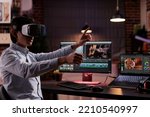 Freelancer using vr glasses to edit movie footage with computer software app. Videographer editing film montage with visual and sound effects, creating video for multimedia production.