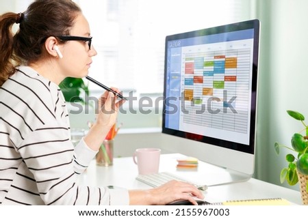 Freelancer woman using calendar on computer to improve time management, plan appointments, events, tasks and meetings efficiently, improve productivity, organize week day and work hours. Foto stock © 