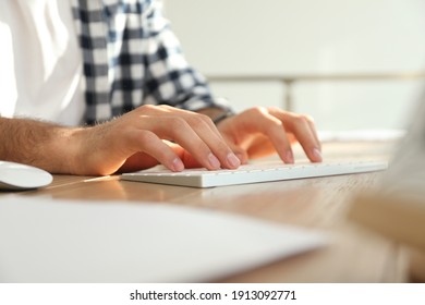 Freelancer working on computer at table indoors, closeup