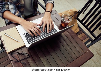 Freelancer Working On Laptop In Outdoor Cafe, View From Above