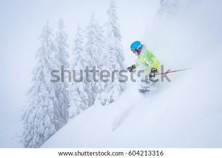Freeride skiier riding in deep powder snow