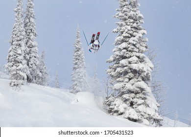 A Freerider In Bright Gear Jumps Between Christmas Trees With A Backflip Element. Prof Skier In A Beautiful Flight At High Altitude. Winter Fun At The Ski Resort. Good Powder Day. Funny Skiing