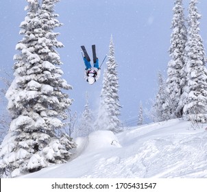 A Freerider In Bright Gear Jumps Between Christmas Trees With A Backflip Element. Prof Skier In A Beautiful Flight At High Altitude. Winter Fun At The Ski Resort. Good Powder Day. Funny Skiing