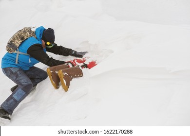 Freerider Digging Snow Avalanche To Safe A Person Buried By An Avalanche. Danger Extreme Concept