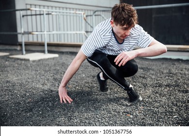 Freerunner is landing on gravel after jumping from a rooftop. - Powered by Shutterstock