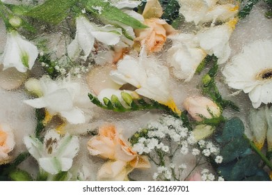 freesia, gypsophila, alstroemeria and roses on beige background through the glass with water on it