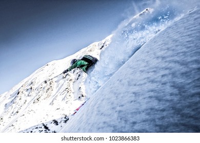 Freeskier riding down a powder line