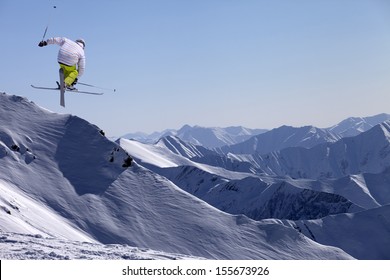 Freestyle Ski Jumper With Crossed Skis In Snowy Mountains