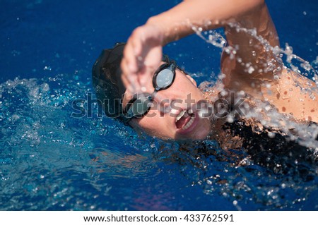 Freestyle swimming close-up. Selective focus set on eyes, blurred hand in motion, polarization filter