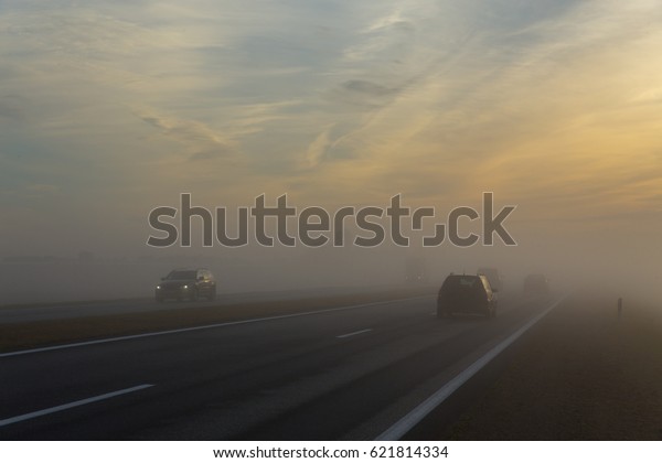 Freeway and a car in\
fog at early morning