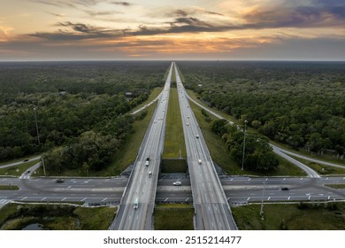 Freeway overpass junction in Florida with fast moving traffic cars and trucks in American rural area at sunset. Interstate transportation infrastructure in USA