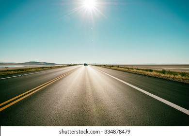 Freeway / Road In The Desert - At The Horizon A Car Speeds Up