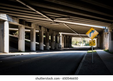 Freeway Underpass With A Curving Road Sign