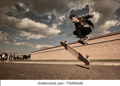 Freeze action shot of talented skillful young European male skateboarder jumping high while performing kick flip trick on his wooden long board on sunny summer day. Extreme and adrenalineâ?¯concept - Powered by Shutterstock