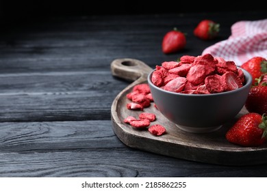 Freeze dried and fresh strawberries on black wooden table. Space for text - Shutterstock ID 2185862255