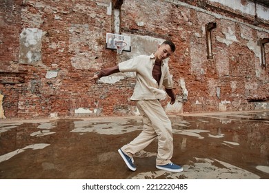 Freeze Frame Of Male Breakdancer Performing Against Shabby Brick Wall Outdoors, Copy Space