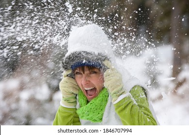 A Freeze Frame Of A Screaming Woman In Winter Wear Getting Hit With A Snow Ball From Behind