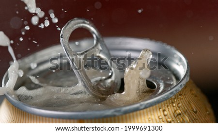 Freeze motiion of opening a can of beer.