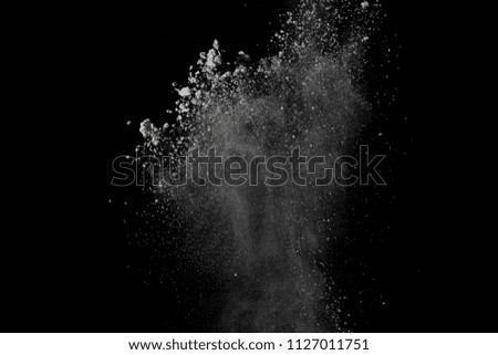 Freeze motion of colorful dust explosion on white background. Stop motion the movement of colorful powder on dark background. Explosive of colorful cloud on black background.