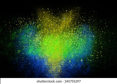 Freeze motion colorful powder exploding  isolated black  dark background  Abstract design dust cloud  Particles explosion screen saver wallpaper and copy space  Vivid yellow blue green ash