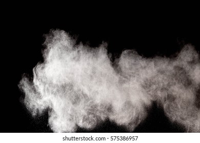 Freeze motion explosion of white dust on a black background. By throwing talcum powder out of hand. Stopping the movement of white powder on dark background. - Shutterstock ID 575386957