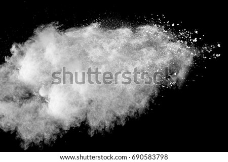 Freeze motion explosion of white dust on a black background.Stopping the movement of white powder on dark background.