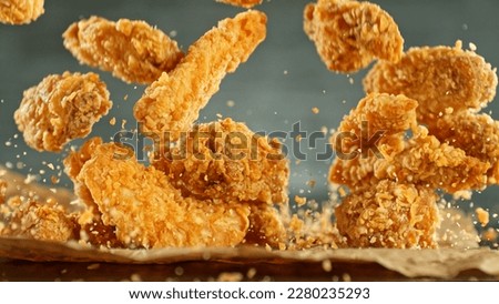 Freeze motion of flying pieces of fried chicken pieces. Concept of levitating food.