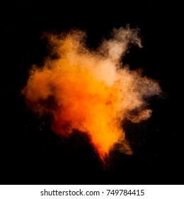 Freeze motion of orange dust explosion isolated on black background