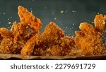 Freeze Motion Shot of Flying Fresh Fried Chicken Wings or Strips, Close-up