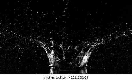 Freeze Motion Of Water Splash On Black Background In Crown Shape. Studio Shot, Space For Product Placement.