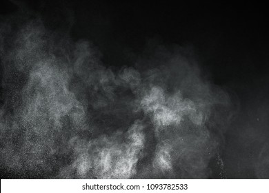 Freeze motion of white dust explosion on black background. Stopping the movement of white powder on dark background. Explosive powder white on black background. - Shutterstock ID 1093782533