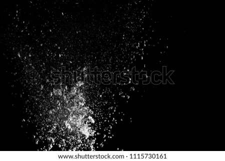 Freeze motion of white dust explosion on black background. Holi cloud