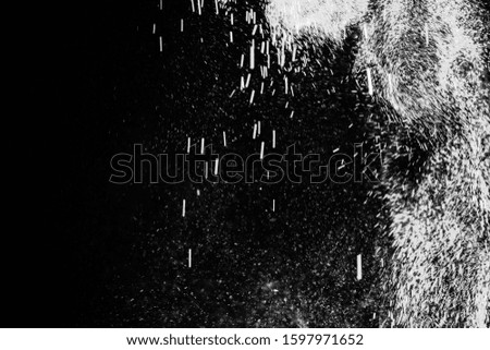 Freeze motion of white dust explosion on black background. Stopping the movement of white powder on dark background.
 Explosive powder white on black background.