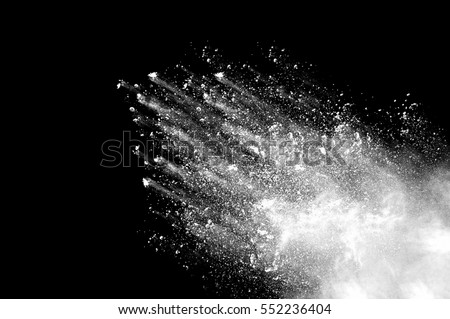 Freeze motion of white dust explosion on black background. Stopping the movement of white powder on dark background. Explosive powder white on black background.