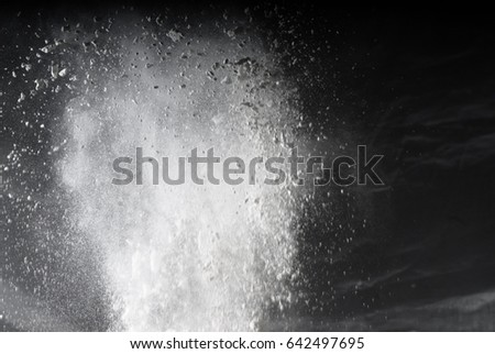 Freeze motion of white dust explosion on black background.Powder explosion. Abstract dust overlay texture.